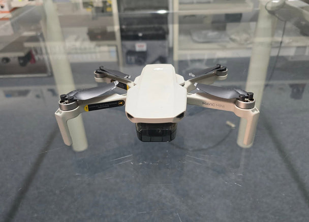 Pre-Owned DJI Mavic Mini 1 drone in a display case, showcasing its compact design and features.