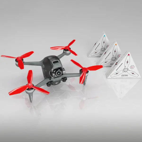 DJI FPV drone with red propellers and three obstacle avoidance pyramids on a reflective surface.