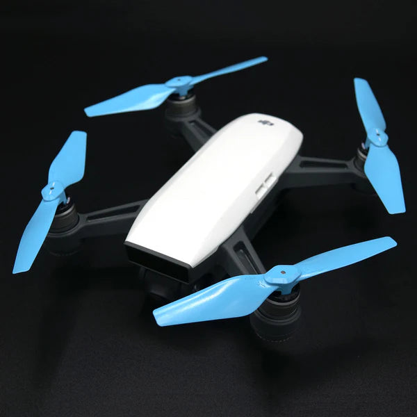DJI Spark drone with blue STEALTH propellers on a black background, showcasing low-noise and high-performance features.
