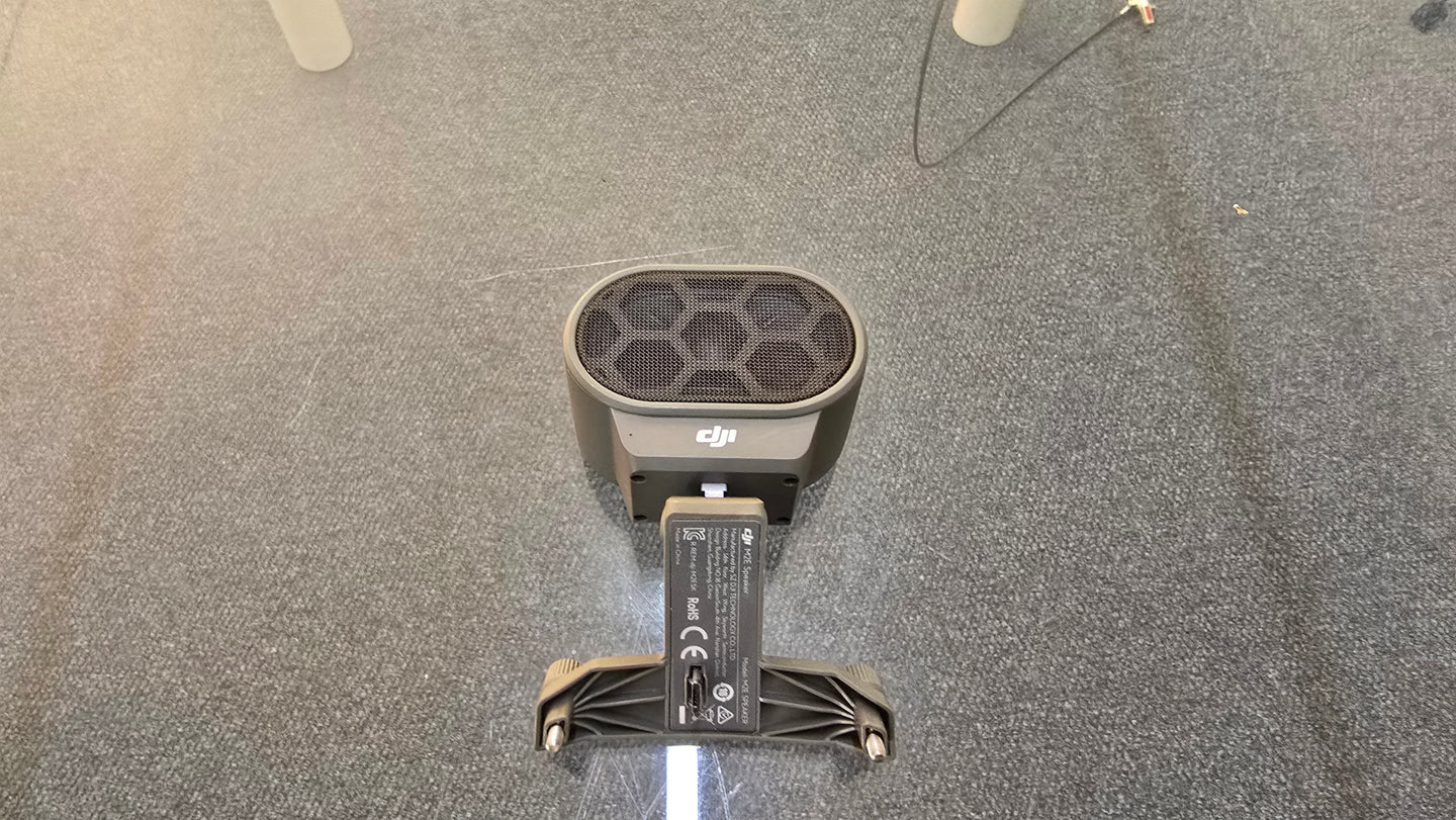 Pre-Owned DJI Mavic 2 Dual Speaker Module from above view on carpeted surface.