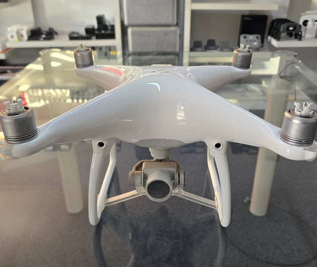 Pre-owned DJI Phantom 4 Standard drone with gimbal and propellers, showcasing its sleek white design.